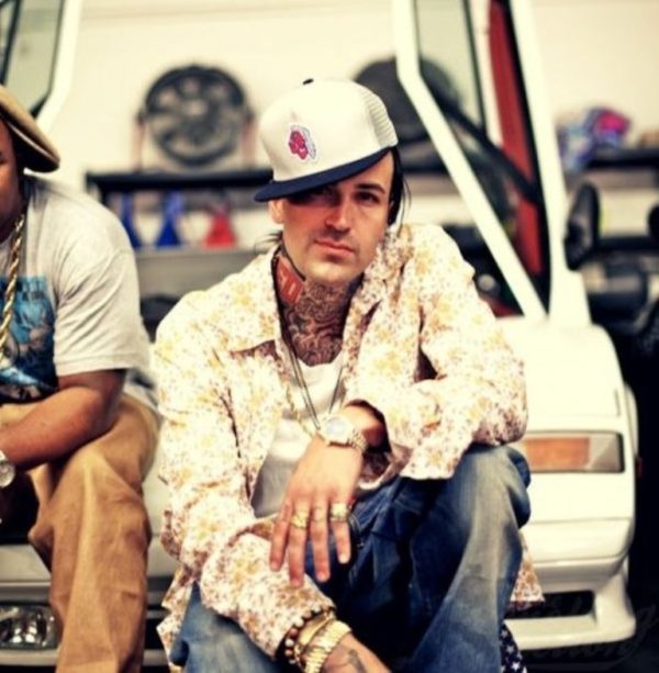 Pistol And Feathers Tattoo On Yelawolf Neck